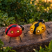 Pack de dos mariquitas solares para jardín, una roja y una amarilla dorada, con luces LED cálidas.