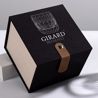 Caja de presentación Girard Diamant negra, con laterales de madera clara, dibujo del vaso y cierre marrón